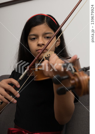 A young girl is playing the violin A young girl is playing the violin 139679924