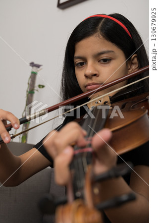 A young girl is playing the violin A young girl is playing the violin 139679925