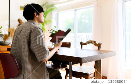自宅のダイニングで読書をする男性 自宅のダイニングで読書をする男性 139680054