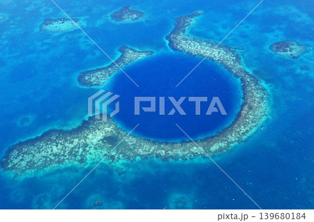 世界遺産ベリーズのブルーホール　サンゴ礁に囲まれた深い青の円形海洞を空から望む 139680184
