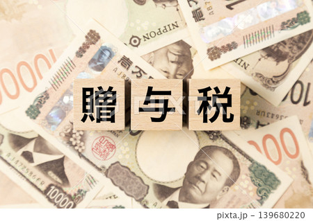 「贈与税」と書かれたブロックとたくさんの一万円札 「贈与税」と書かれたブロックとたくさんの一万円札 139680220