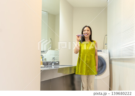 脱衣所で歯磨きをする若い女性 脱衣所で歯磨きをする若い女性 139680222