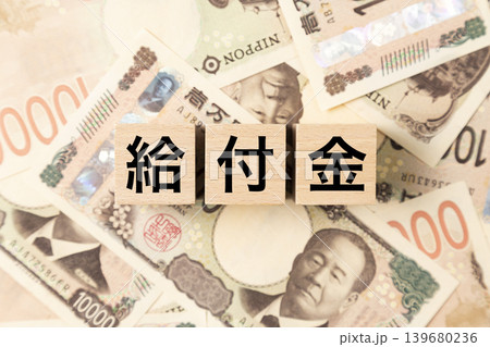 「給付金」と書かれたブロックとたくさんの一万円札 「給付金」と書かれたブロックとたくさんの一万円札 139680236