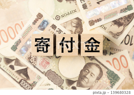 「寄付金」と書かれたブロックとたくさんの一万円札 「寄付金」と書かれたブロックとたくさんの一万円札 139680328