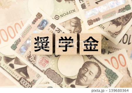 「奨学金」と書かれたブロックとたくさんの一万円札 「奨学金」と書かれたブロックとたくさんの一万円札 139680364