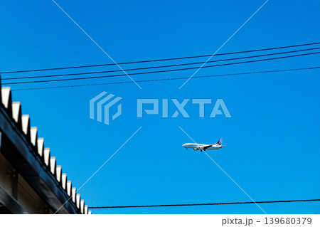 青空を飛行する旅客機と電線 139680379