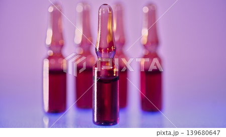 Red glass medical ampoules close up on neon pink blue background 139680647