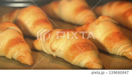 Freshly baked croissants cooling on a baking tray in a kitchen setting during the early morning hours Freshly baked croissants cooling on a baking tray in a kitchen setting during the early morning hours 139680847