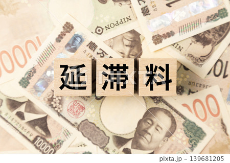 「延滞料」と書かれたブロックとたくさんの一万円札 「延滞料」と書かれたブロックとたくさんの一万円札 139681205