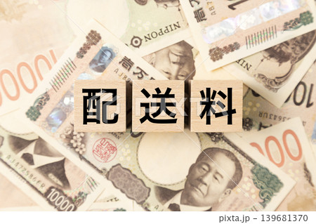 「配送料」と書かれたブロックとたくさんの一万円札 「配送料」と書かれたブロックとたくさんの一万円札 139681370