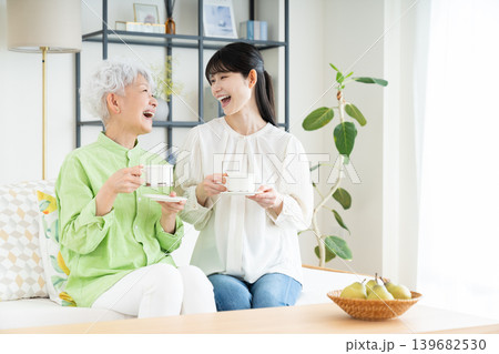 リビングでコーヒーを飲むシニアの母親とミドルの娘 リビングでコーヒーを飲むシニアの母親とミドルの娘 139682530