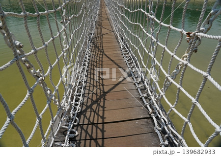 Rope Bridge Over Water Perspective Summer Day Outdoors Rope Bridge Over Water Perspective Summer Day Outdoors 139682933