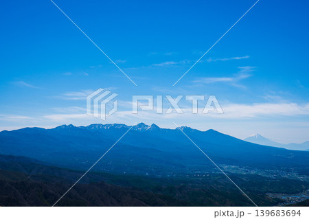 霧ヶ峰から望む鮮烈な残雪の八ヶ岳連峰と右奥にそびえる富士山 霧ヶ峰から望む鮮烈な残雪の八ヶ岳連峰と右奥にそびえる富士山 139683694