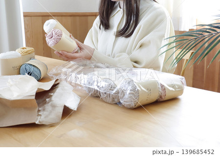 明るい部屋で毛糸を見る女性 明るい部屋で毛糸を見る女性 139685452