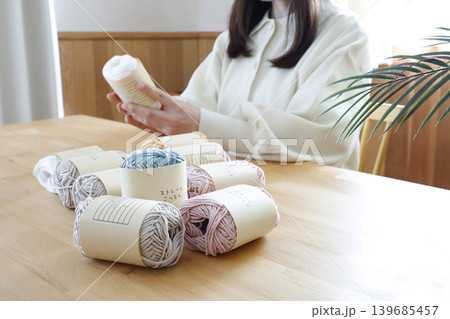 明るい部屋で毛糸を見る女性 139685457