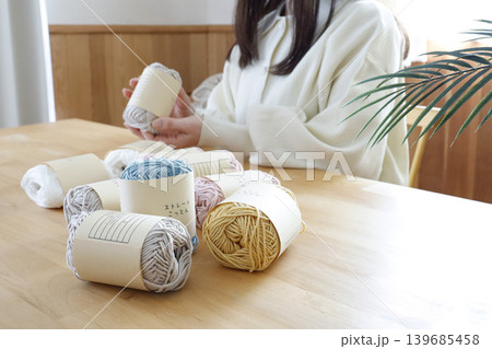 明るい部屋で毛糸を見る女性 明るい部屋で毛糸を見る女性 139685458