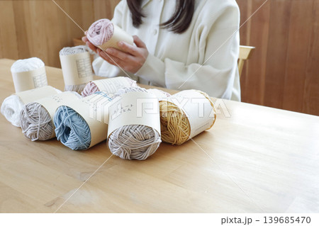 明るい部屋で毛糸を見る女性 139685470