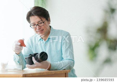 一眼レフカメラのホコリを取る男性 一眼レフカメラのホコリを取る男性 139685593