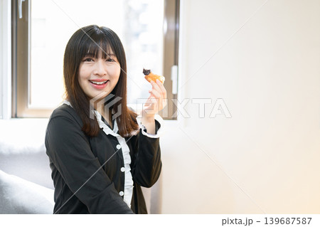 ベッドでドーナツを食べる日本人女性 139687587