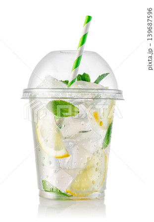 Lemonade or mojito style drink with lemon slices, ice cubes and fresh mint leaves in clear takeaway plastic cup isolated on white 139687596