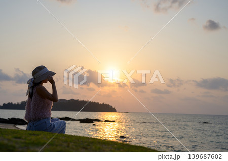 沖縄の夕焼けを眺める日本人女性の後ろ姿 沖縄の夕焼けを眺める日本人女性の後ろ姿 139687602