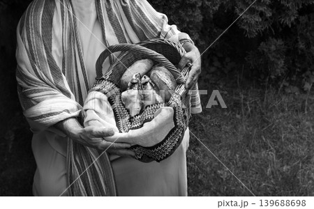 Man holding a basket with fish and bread 139688698