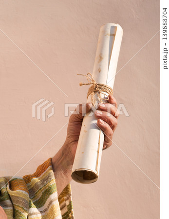 Male hand holding an old scroll Male hand holding an old scroll 139688704