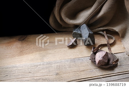 An antique leather sling lies on wooden desk An antique leather sling lies on wooden desk 139688719