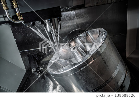 CNC milling machine machining metal impeller with coolant spray. CNC milling machine machining metal impeller with coolant spray. 139689526