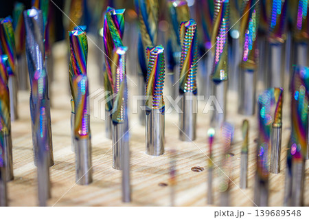 Colorful carbide milling cutters in wooden holder. Colorful carbide milling cutters in wooden holder. 139689548