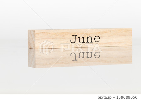 a wooden cube with the inscription June on a white background 139689650