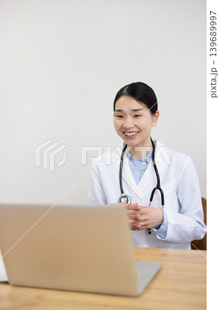 パソコンでオンライン通話をする白衣を着た日本人女性医師 パソコンでオンライン通話をする白衣を着た日本人女性医師 139689997