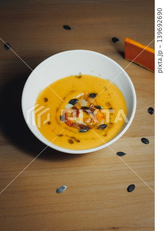 Pumpkin soup with roasted seeds, warm and inviting on wood Pumpkin soup with roasted seeds, warm and inviting on wood 139692690