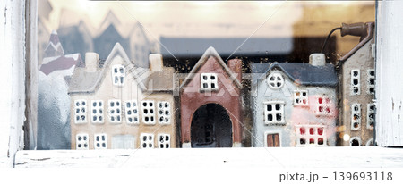 Small houses figurines in a window 139693118