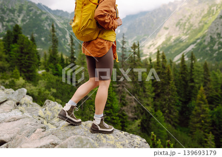 Female legs in hiking boots on hiking trail, on top of mountain outdoors. Nature, relaxation concept 139693179
