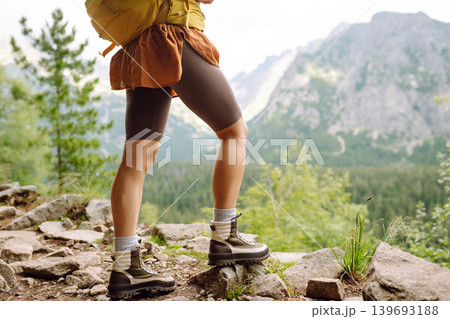 Female legs in hiking boots on hiking trail, on top of mountain outdoors. Nature, relaxation concept Female legs in hiking boots on hiking trail, on top of mountain outdoors. Nature, relaxation concept 139693188