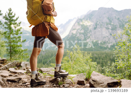 Female legs in hiking boots on hiking trail, on top of mountain outdoors. Nature, relaxation concept Female legs in hiking boots on hiking trail, on top of mountain outdoors. Nature, relaxation concept 139693189
