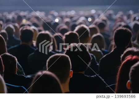 Crowd of people watching live concert in dark venue, backs of heads and blurred stage lights Crowd of people watching live concert in dark venue, backs of heads and blurred stage lights 139693566