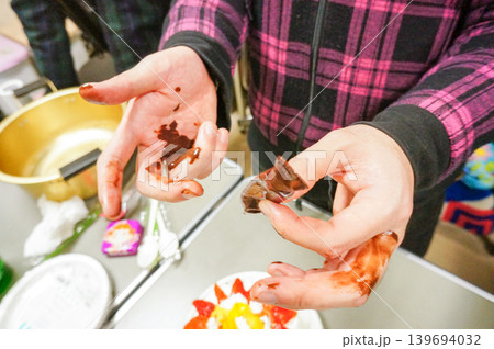 チョコレートを手作業でケーキに飾りつける様子 139694032