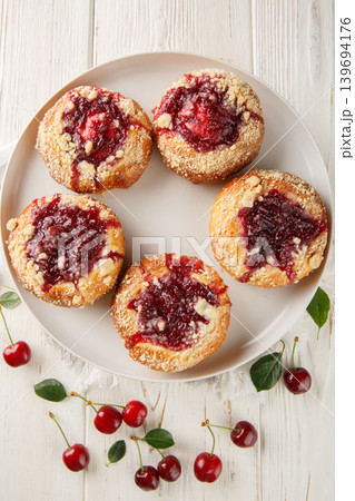 Polish yeast bun drozdzowka with cherry and crumble closeup on the plate on the wooden table. Vertical top view Polish yeast bun drozdzowka with cherry and crumble closeup on the plate on the wooden table. Vertical top view 139694176