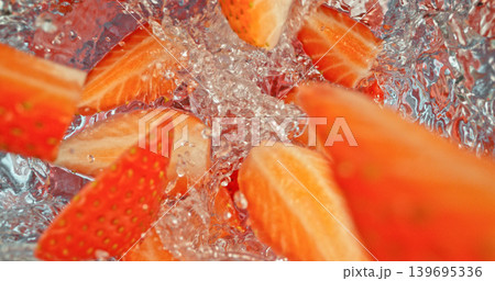 Fresh strawberries falling into sparkling water with bubbles and splashes. Vibrant red fruit macro photo, perfect for beverage, freshness, summer, cocktail and healthy lifestyle visuals. 139695336