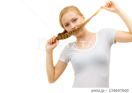 Blonde girl covering her mouth with braid hair Blonde girl covering her mouth with braid hair 139697600