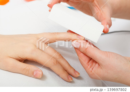 Preparing nails before manicure, beautician file nails Preparing nails before manicure, beautician file nails 139697802