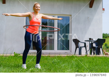 Young woman with hoola hoop outdoors Young woman with hoola hoop outdoors 139697840