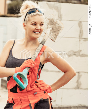 Woman using shovel on constriction site Woman using shovel on constriction site 139697982