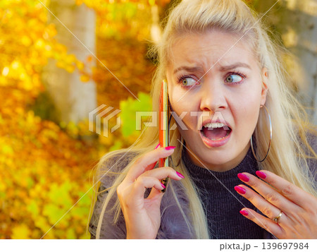 Female talking on mobile phone outdoor 139697984