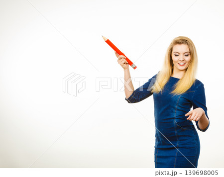 Positive woman holds big pencil in hand Positive woman holds big pencil in hand 139698005