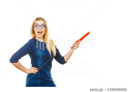 Joyful woman holds big pencil in hand Joyful woman holds big pencil in hand 139698008