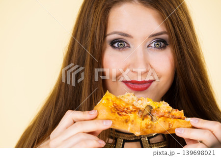 Woman eating hot pizza slice 139698021