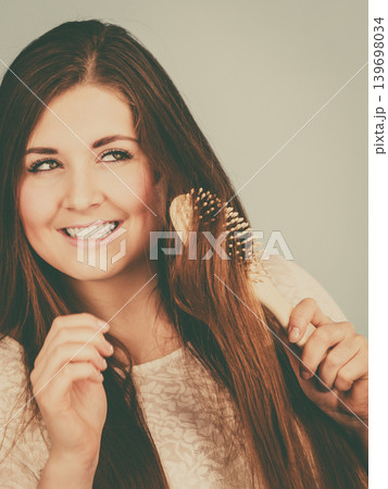 Happy woman brushing her hair Happy woman brushing her hair 139698034